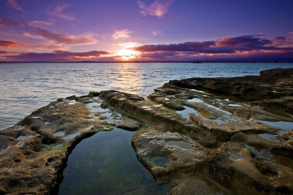 Vista de la puesta de sol desde la playa rocosa