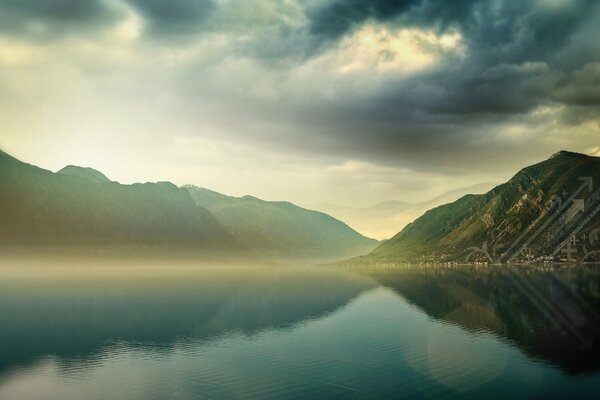 Espejo de agua del lago de montaña bajo las nubes