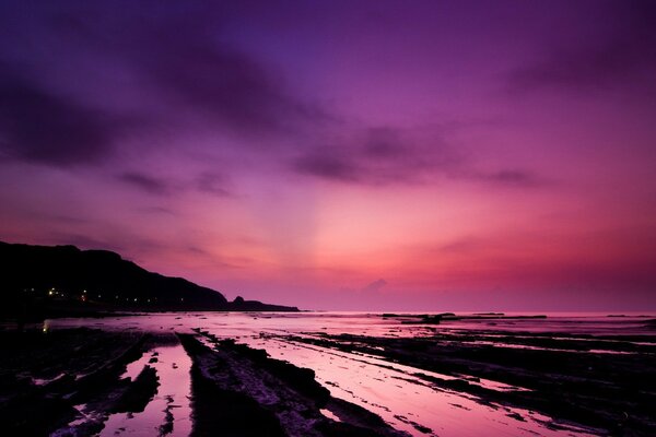 Coucher de soleil dans les tons roses sur le rivage