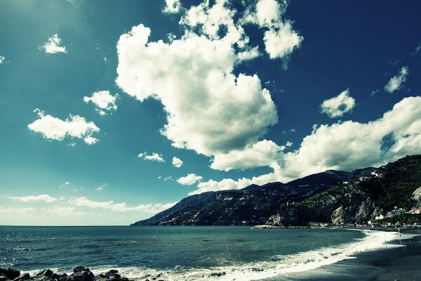 Rocky seashore. White clouds