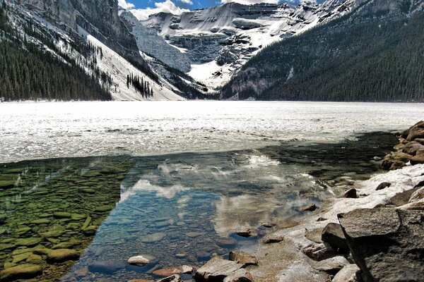 Riflessione delle montagne in un fiume trasparente