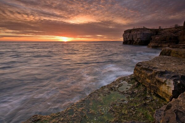 Costa de piedra junto al agua al atardecer