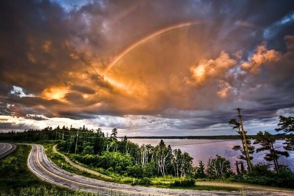 Route sinueuse sur fond de nuages et d arc-en-ciel