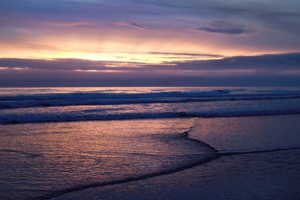 Olas del mar en medio de la puesta de sol y las nubes