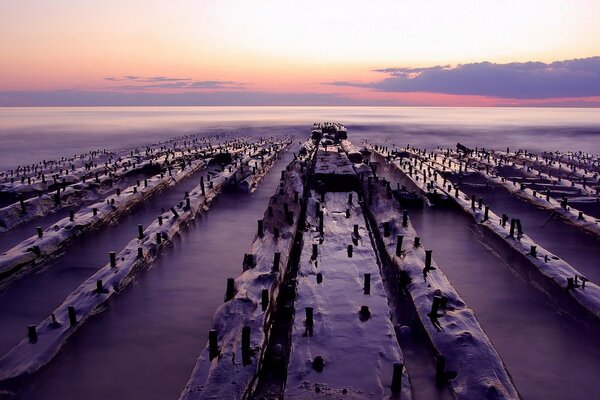 Puesta de sol en el horizonte con bloques de la costa