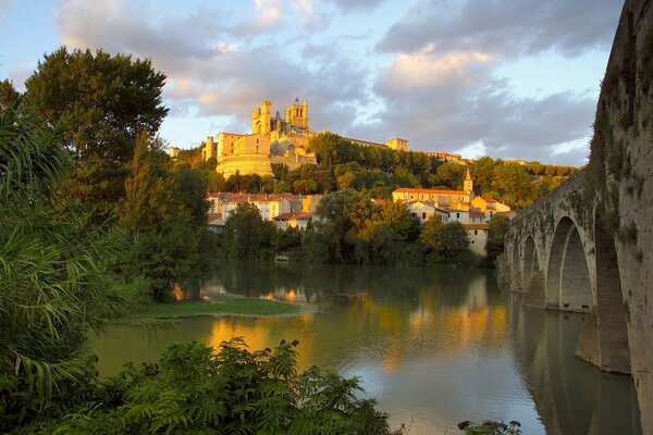 Blick auf die Kirche des Heiligen Nazarus in Frankreich von der Seite des Flusses und der Brücke