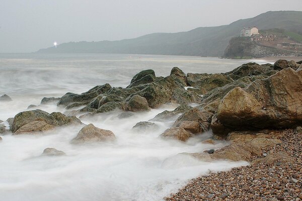 Surf on the rocky shore. Water splashes