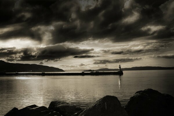 Black and white photo of the lighthouse in the bay at night