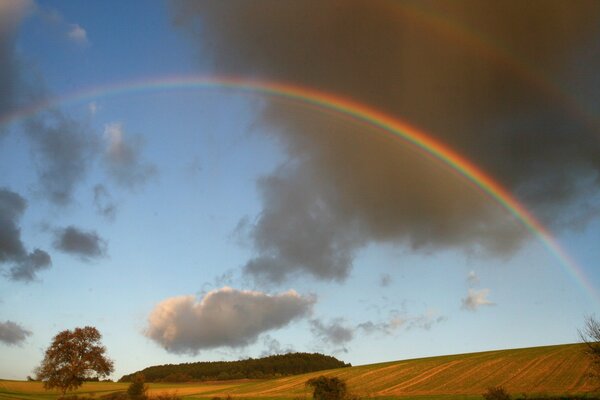 Rainbow over fields and forests and high hills