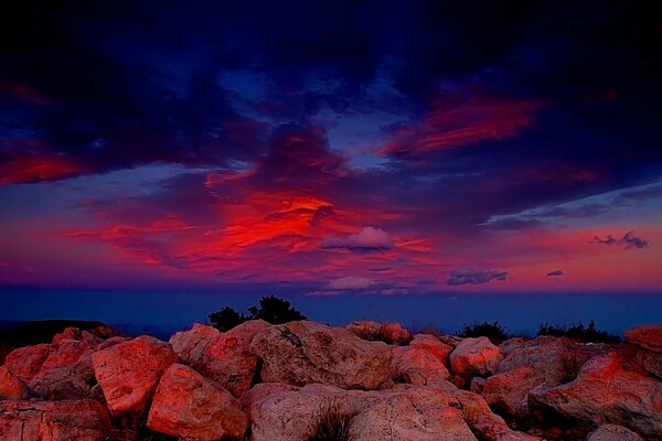 Scarlet sunset on a background of stones