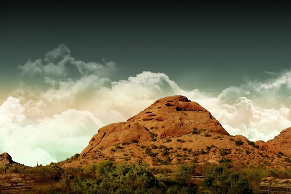 Mountain peak on the background of cotton wool clouds