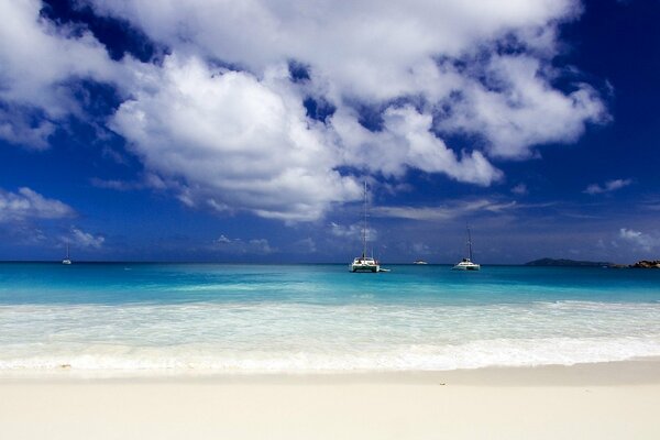 Sandy beach, blue sea water and blue sky