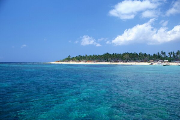 Mer turquoise baignant la plage avec des huttes