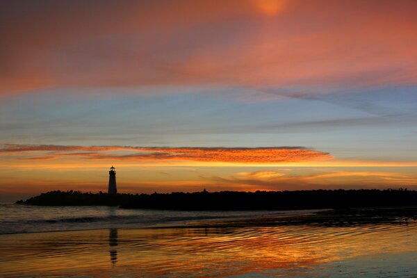 Reflet du phare et du coucher de soleil dans le lac