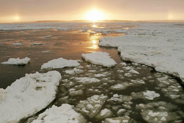 Лед в воде на фоне солнца