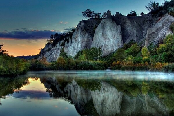 Graue Felsen spiegeln sich in der Oberfläche des Sees wider