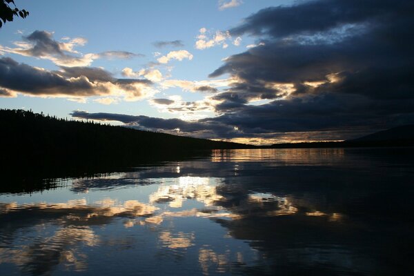 The evening sky is preparing for a storm over the river