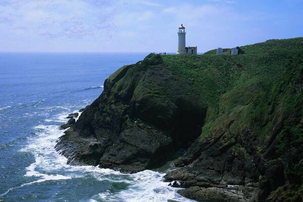 A lonely lighthouse on a rock. Sea surf