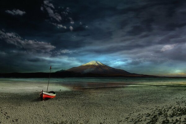 Red boat on the sandy seashore