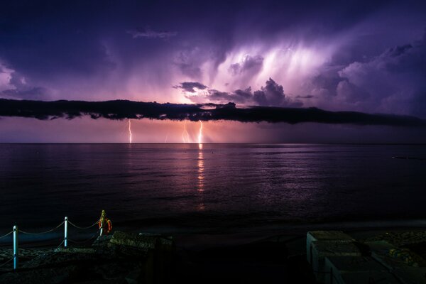 Italy. Night pier. Sea. Clouds and thunderstorms