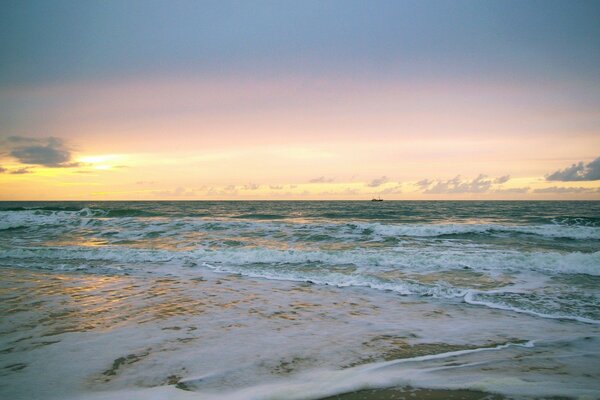 Amanecer sobre el mar con olas