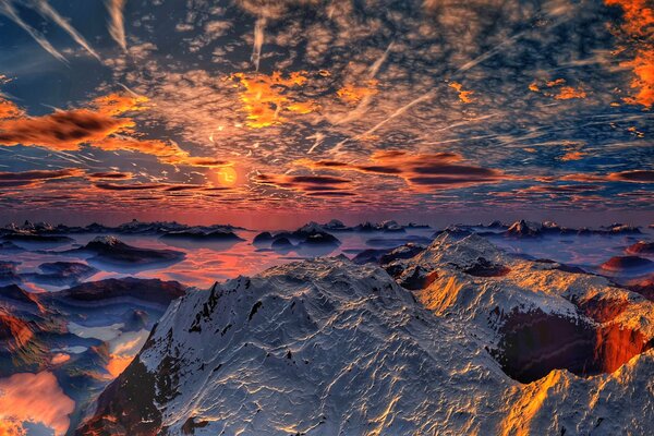 Schneebedeckte Berge im Hintergrund des Sonnenuntergangs