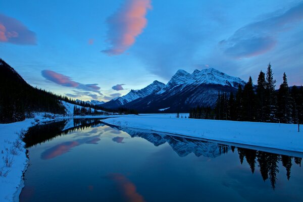 Distese invernali lungo il fiume verso le montagne