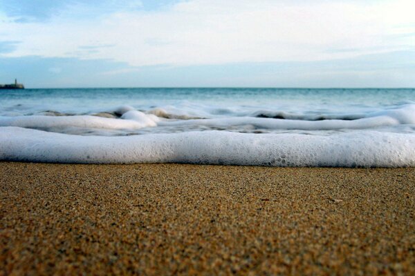 Sandy beach and sea waves near