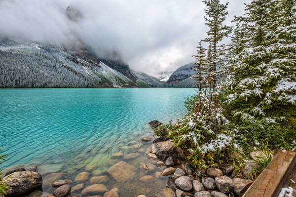 Ein blauer See, der in Bergnebel gehüllt ist