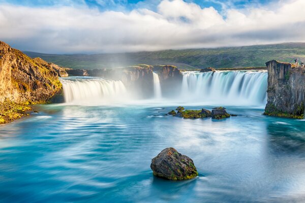 Beautiful waterfall on the background of white clouds