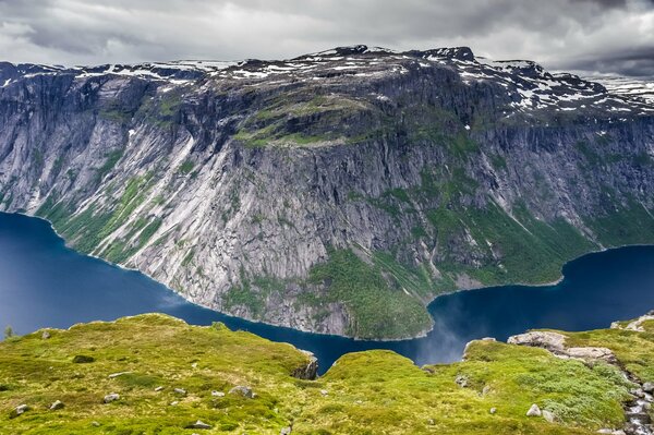 El lago enmarca la montaña verde