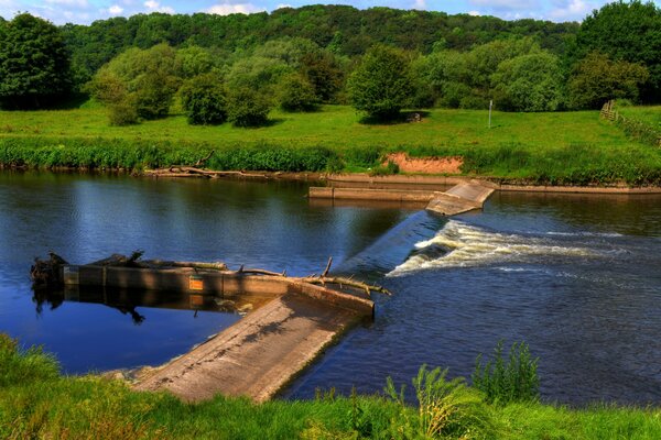 La presa de irek en Inglaterra con madera flotante en los árboles y la hierba