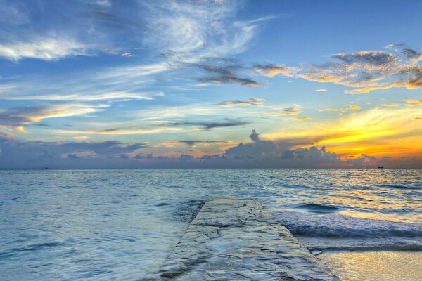 Sonnenuntergang am Meer am Pier. Wolken am Himmel