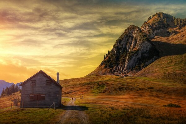 Sky and sun filter treatment. There is a house in the mountains