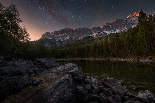 Lago entre las rocas bajo el cielo estrellado