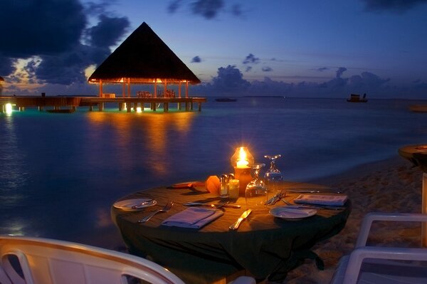 Romantic dinner on the beach in the evening on the background of the ocean to see