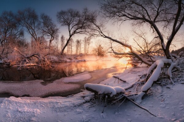 Puesta de sol y río congelado en la nieve