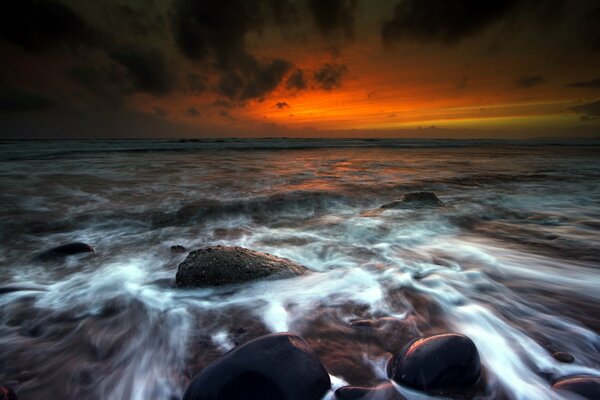 Agua lavando piedras al atardecer