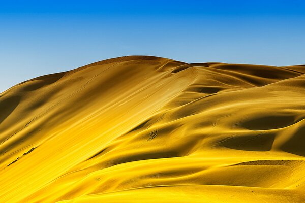 Arena caliente y fluida en un desierto abrasador bajo un cielo lleno