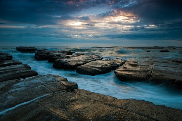 Evening sky on the background of rocks stones and the sea