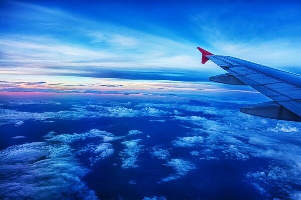 Airplane wing in the blue sky