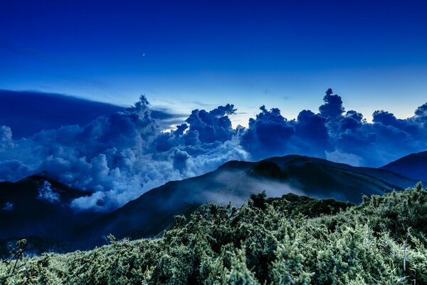 Moonlight in the clouds over the mountains