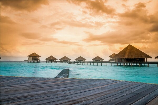 Sunset in the tropics. Houses on the shore