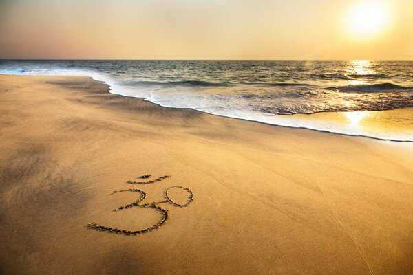 Om symbol on the ocean shore