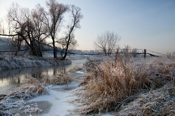 Sunrise landscape on the river at the first frost