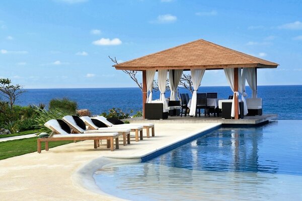 Summer gazebo on the sea with furniture