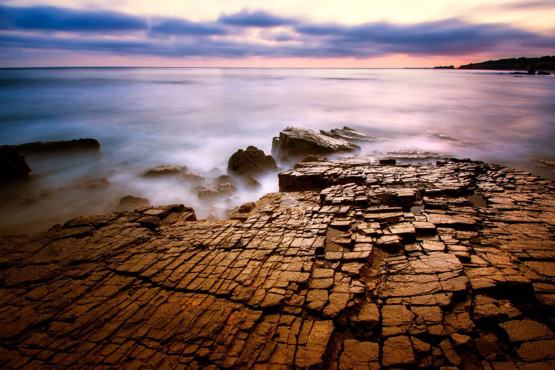 mar rocas grietas superficie tarde nubes