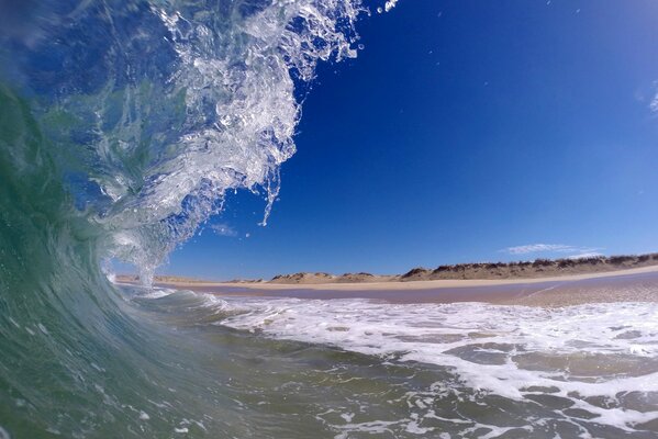 A moment before the splash: a wave rises over the shore