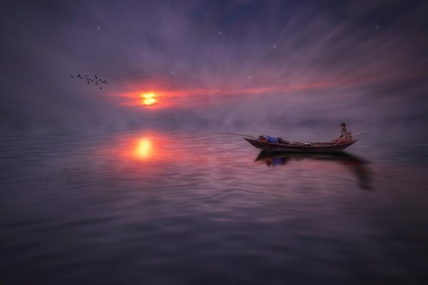 Stunning view of a floating boat with fishermen at sunset