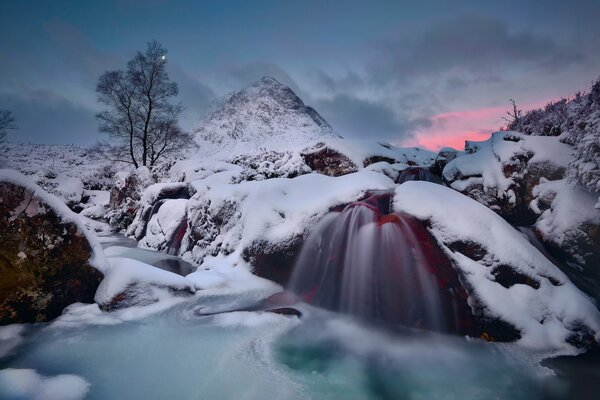 Fluss in den Bergen im Winter abends